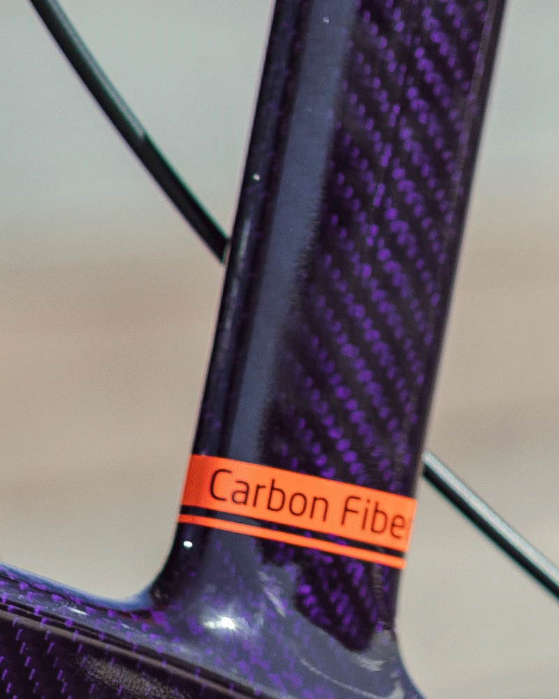 Close-up of a carbon fibre frame with a label reading 'Carbon Fibre'.