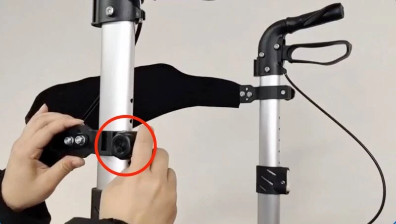 Hands adjusting a backrest bolt on a rollator frame.