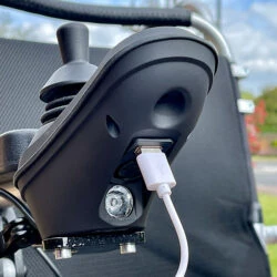 Close-up of joystick with USB port on an electric wheelchair.