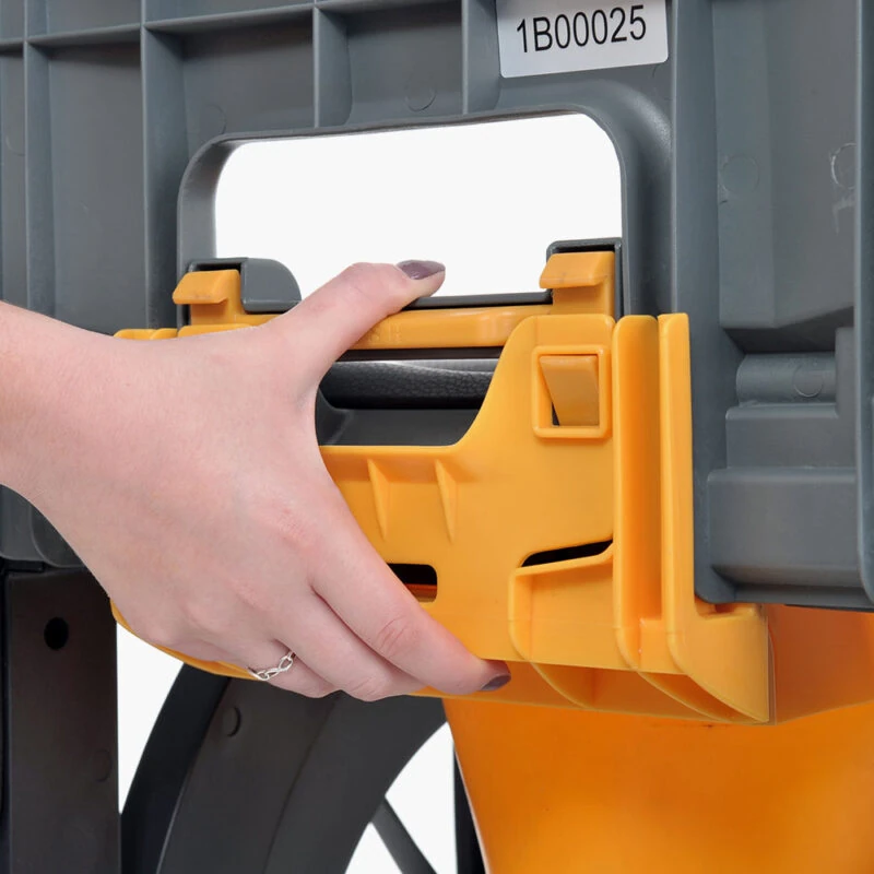 Hand attaching a yellow commode pan to a gray frame.