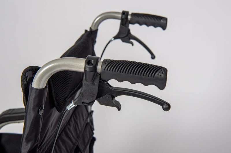 Close-up of wheelchair handles with attendant brakes.
