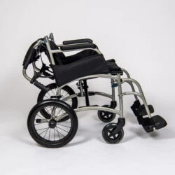 Side view of a folded lightweight transit wheelchair with black seat and silver frame.
