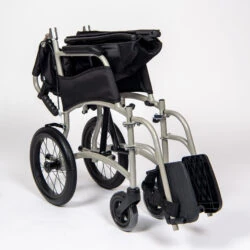 Folded lightweight transit wheelchair with black seat and silver frame.