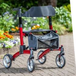 Red fold down rollator with seat and shopping bag on a garden path.