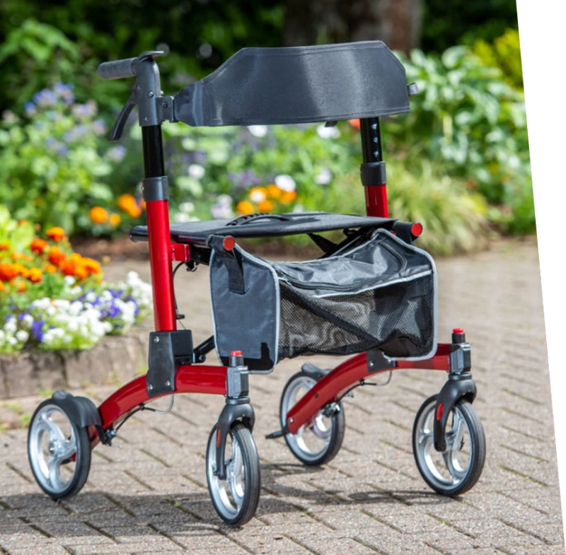 Red fold down rollator with seat and shopping bag on a garden path.