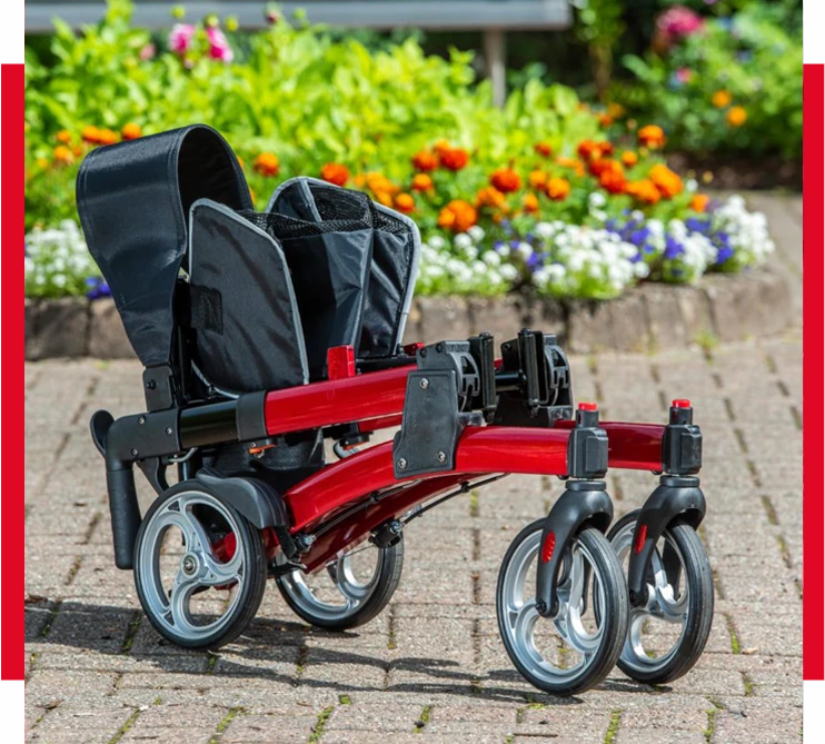 Red rollator folded on a paved path with flowers in the background.