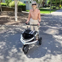 Person using Trionic Veloped Tour 14er rollator in a park.