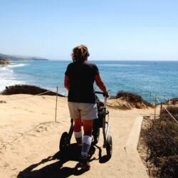 Person using Trionic Veloped Trek 12er on a sandy coastal path.