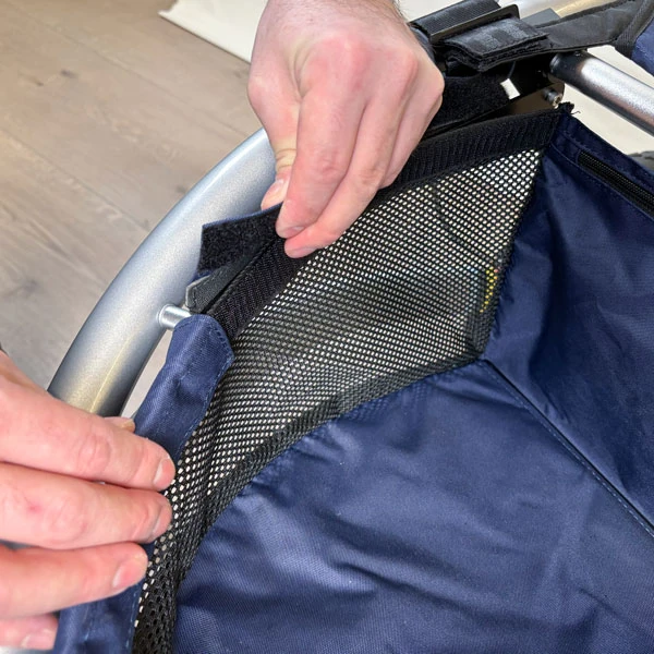 Hands adjusting the mesh seat of a Trionic Veloped Trek 12er.