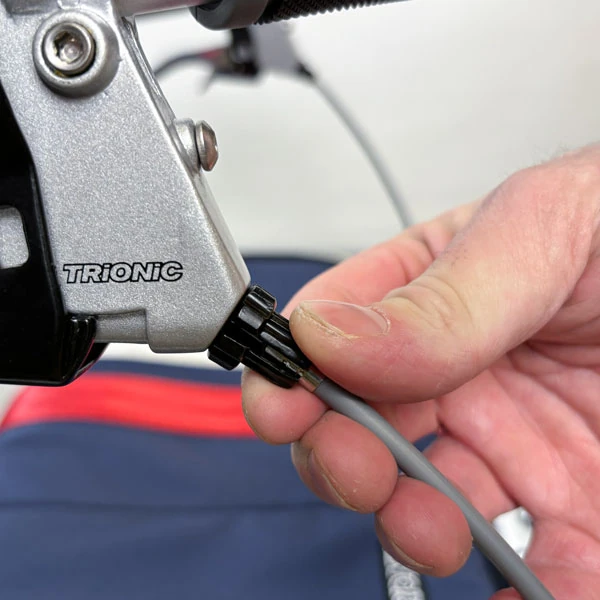Close-up of a hand adjusting the Trionic brake lever on a rollator.