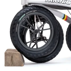 Close-up of a 14-inch wheel of the Trionic Veloped Golf rollator on a concrete block.