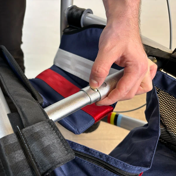 Person adjusting the handle of a Trionic Veloped Trek 12er rollator.