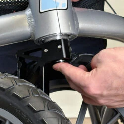 Close-up of a hand adjusting the wheel mechanism on a rollator.