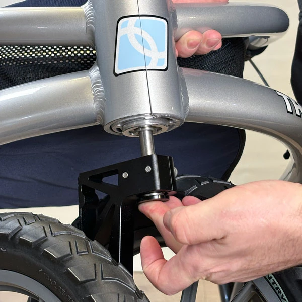Person adjusting the wheel of a Trionic Veloped Trek 12er rollator.