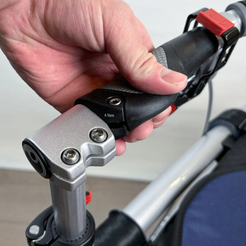 Close-up of a hand adjusting the handlebar grip on a rollator walker.