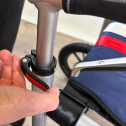 Close-up of a person adjusting the handle clamp on a Trionic Veloped Trek 12er rollator.