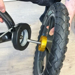 Person attaching a wheel to the Trionic Veloped Trek 12er rollator.