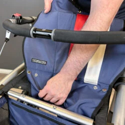 Person adjusting the seat of a Trionic Veloped Trek 12er rollator.