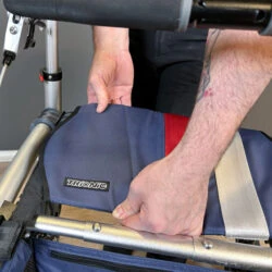 Person adjusting the seat of a Trionic Veloped Trek 12er rollator.