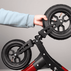 Close-up of a person adjusting the pneumatic wheels on a MobiWalk Upright Walker.