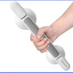 Hand holding a suction grab shower handle with safety lock indicator.