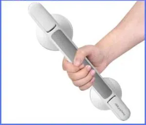 Hand holding a suction grab shower handle with safety lock indicator.