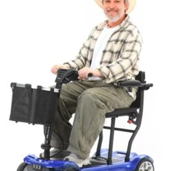 Man sitting on a blue foldable electric mobility scooter with a front basket.