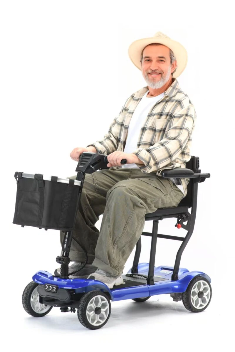 Man sitting on a blue foldable electric mobility scooter with a front basket.