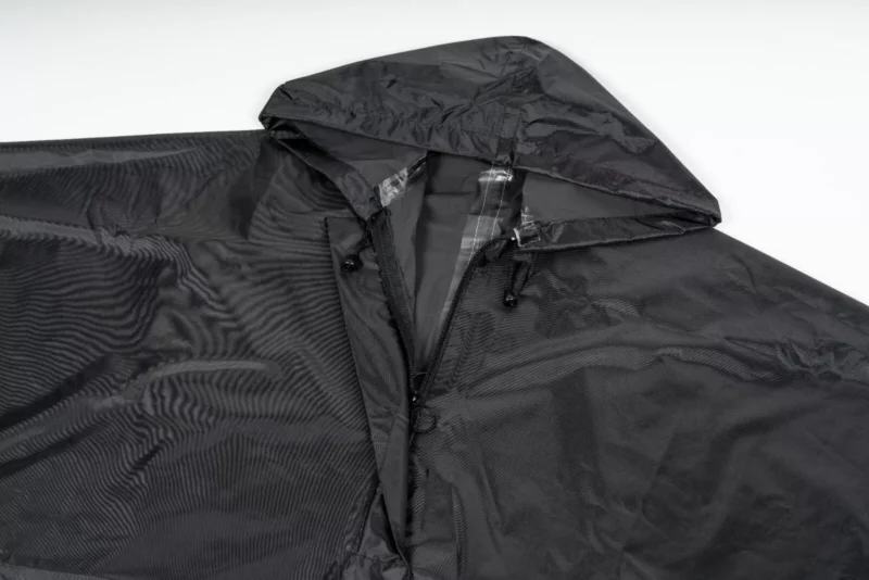 Black waterproof poncho with hood and zipper.