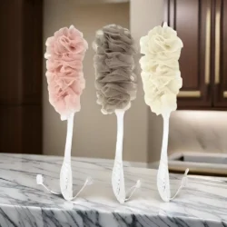 Three long handle bath brushes with soft mesh sponges in pink, brown, and cream.