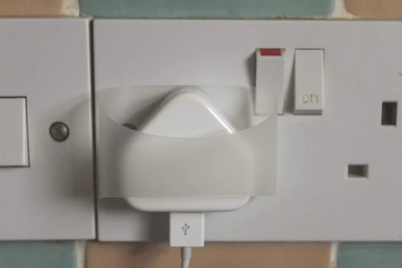 Plug Tugs Puller attached to a plug in a wall socket.