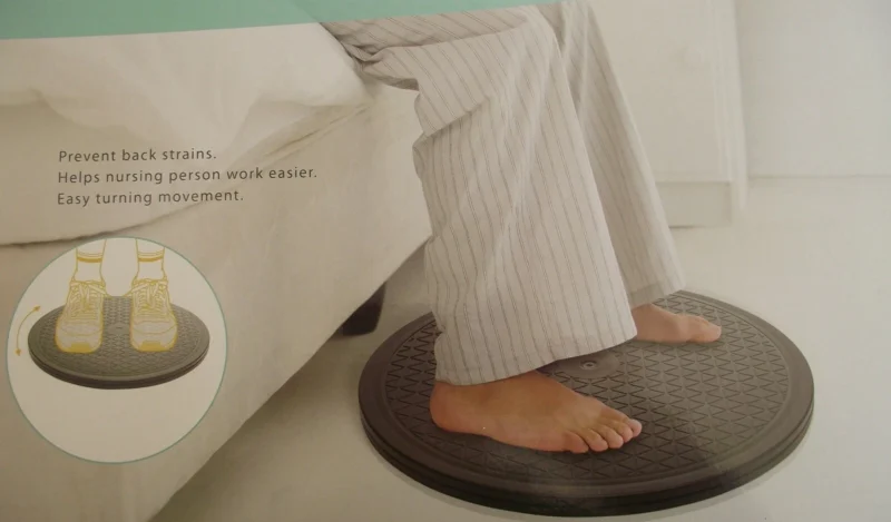 Person standing on a transfer turntable near a bed.