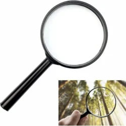 Black handheld magnifier with a forest view through the lens.