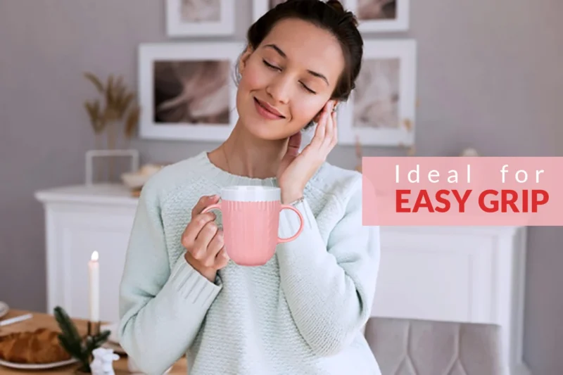 Woman holding a pink two handled mug with text 'Ideal for Easy Grip'.