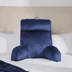Navy lumbar support pillow on a white bed.
