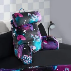 Lumbar support pillow with 'Player Two' text and gaming controller design on a bed.