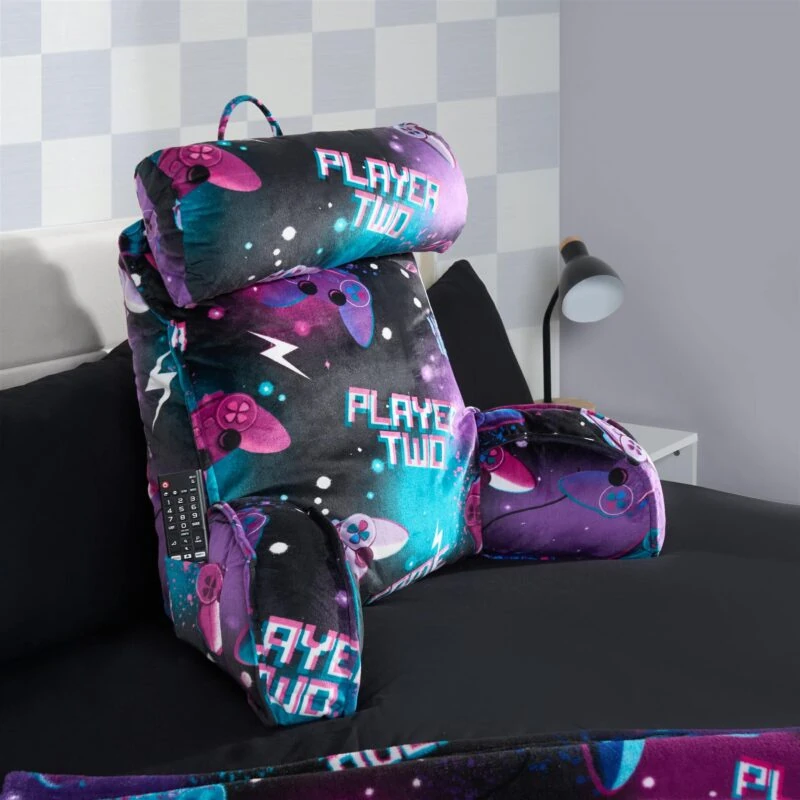 Lumbar support pillow with 'Player Two' text and gaming controller design on a bed.