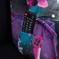 Close-up of a colorful pillow with a remote control in its pocket.