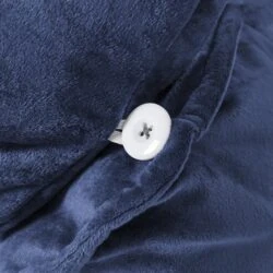 Close-up of navy velvet fabric with a white button on the Cuddle Cushion.