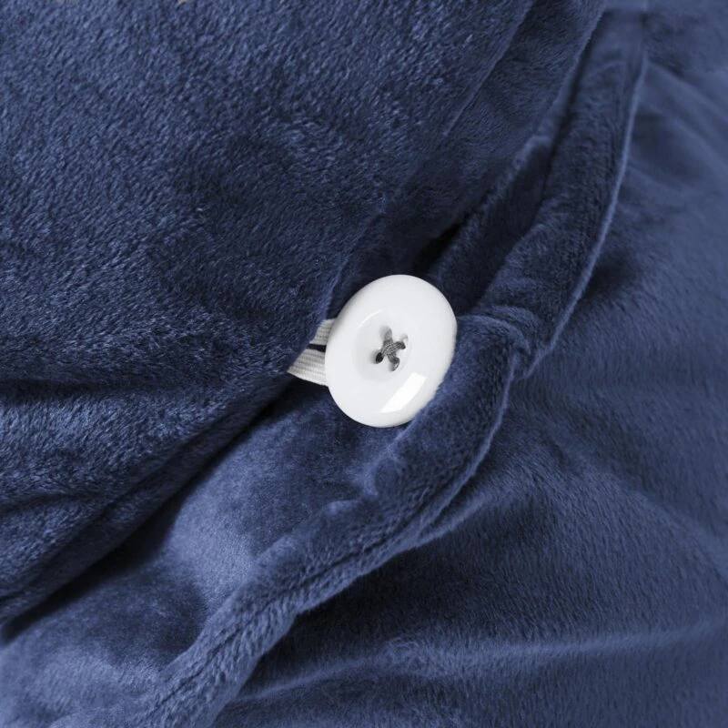 Close-up of navy velvet fabric with a white button on the Cuddle Cushion.