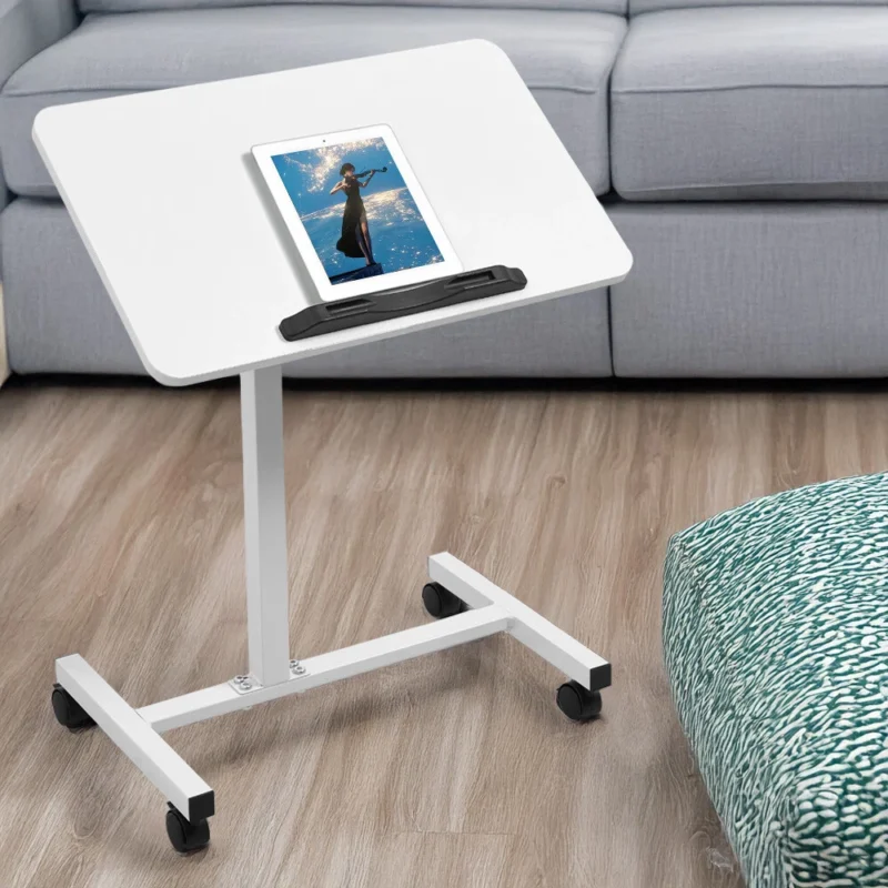 White over bed table with a tablet on it, in a living room setting.