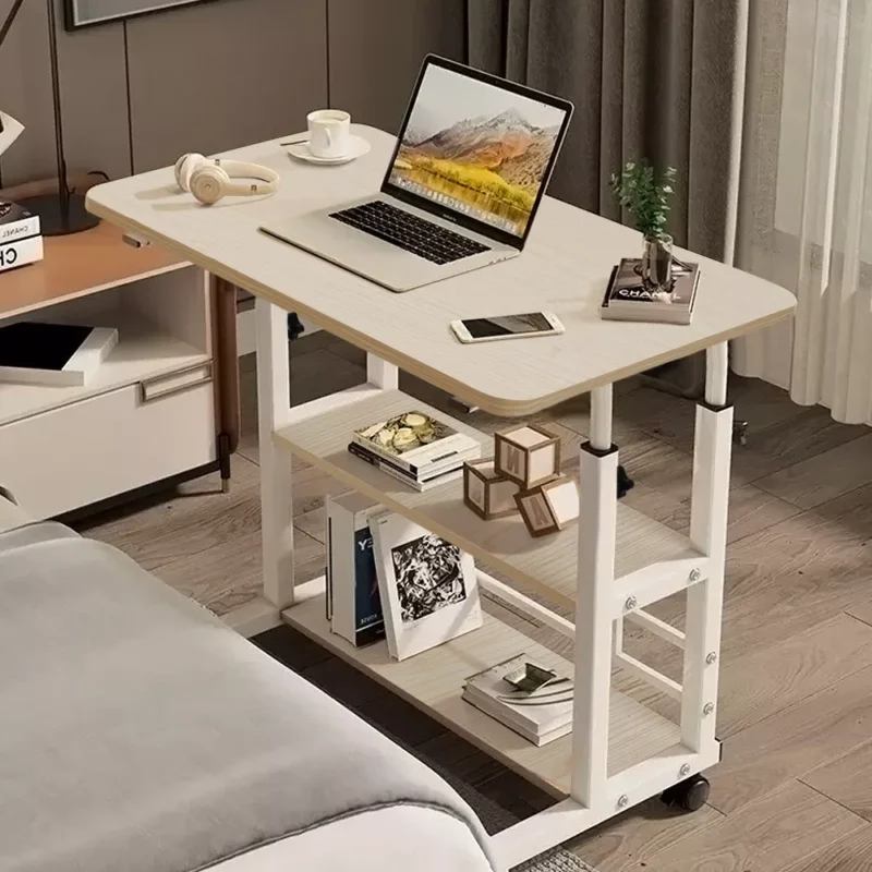 Height adjustable over bed table with a laptop, phone, and books.