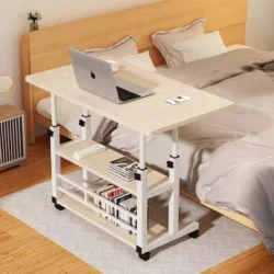 Mobile over bed table with a laptop and books, next to a bed.