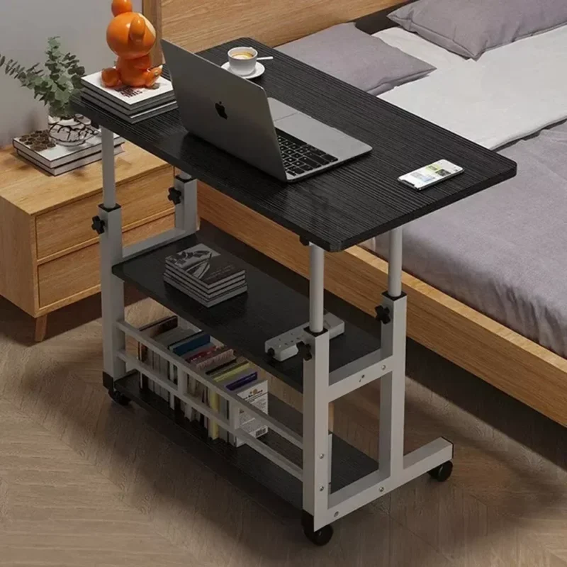 Black over bed table with laptop, books, and a cup of coffee.