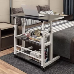 Height adjustable over bed table with a laptop and books on it.