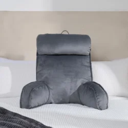 Grey lumbar support pillow on a bed with white bedding.