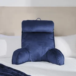 Navy lumbar support pillow on a bed with white bedding.
