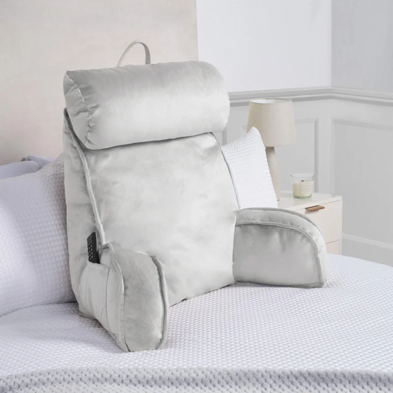 Silver Cuddle Cushion with headrest and arms on a bed.