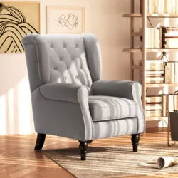 Grey wingback armchair with tufted back in a cozy living room.