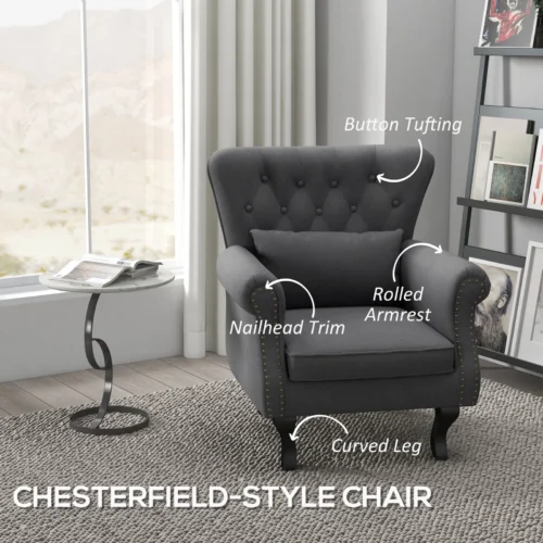 Dark grey Chesterfield-style accent chair with pillow in a living room.